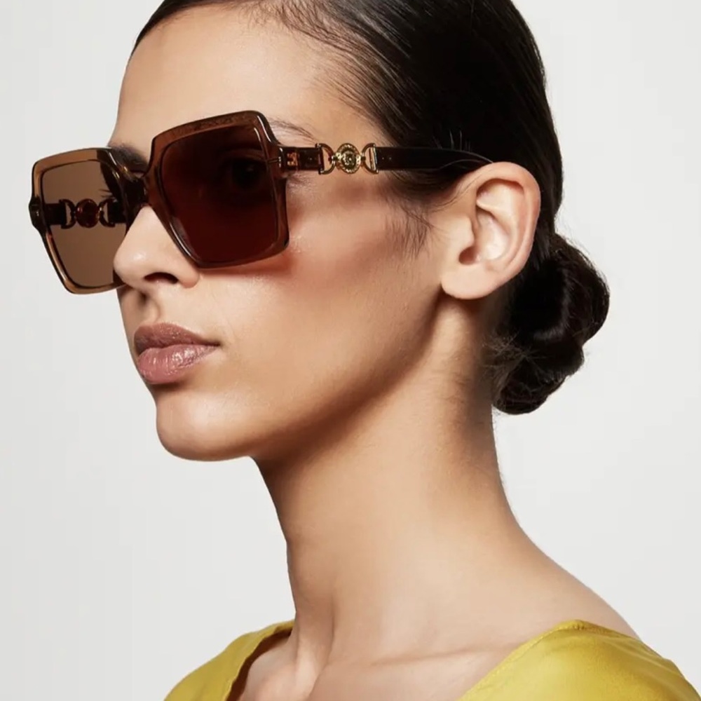 VERSACE LOGO MEDALLIONS FOR A SIGNATURE STATEMENT ON TRANSPARENT BROWN SUNNIES